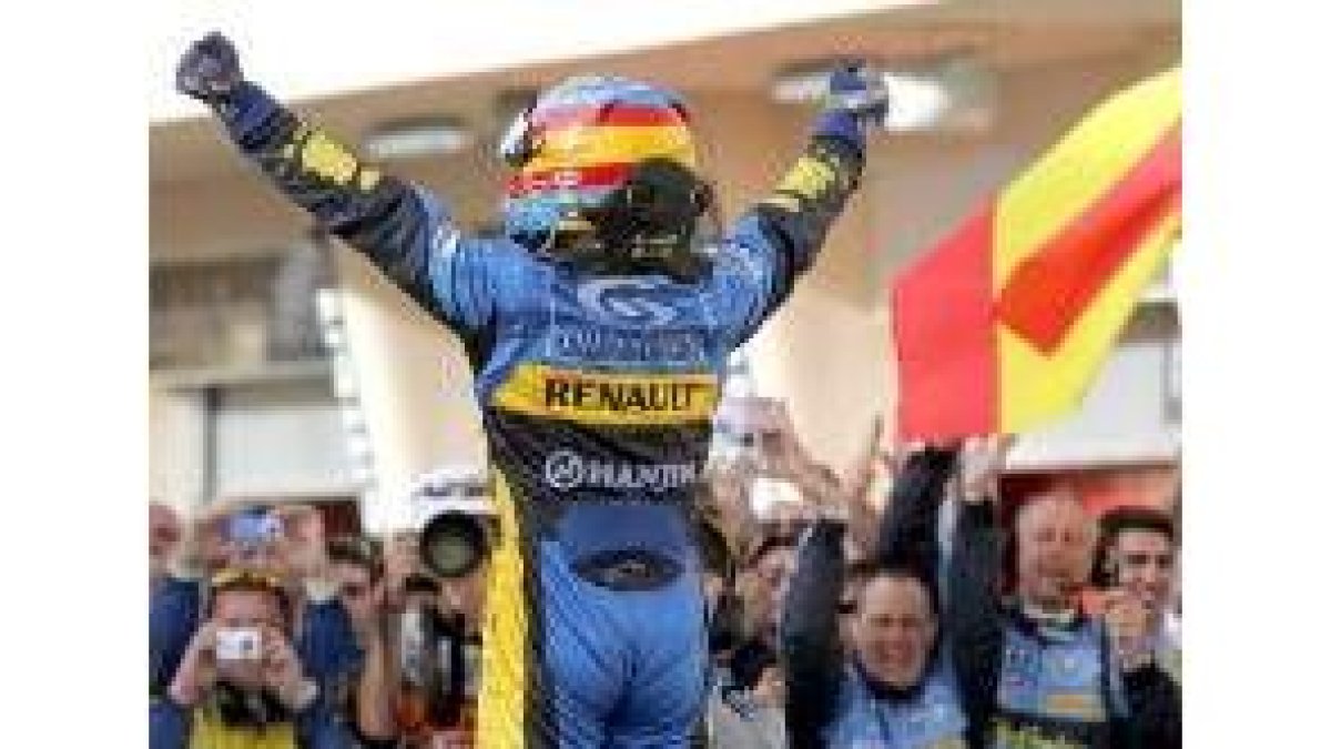Fernando Alonso saluda tras bajarse del coche a los mecánicos de Renault en el circuito de Barhein
