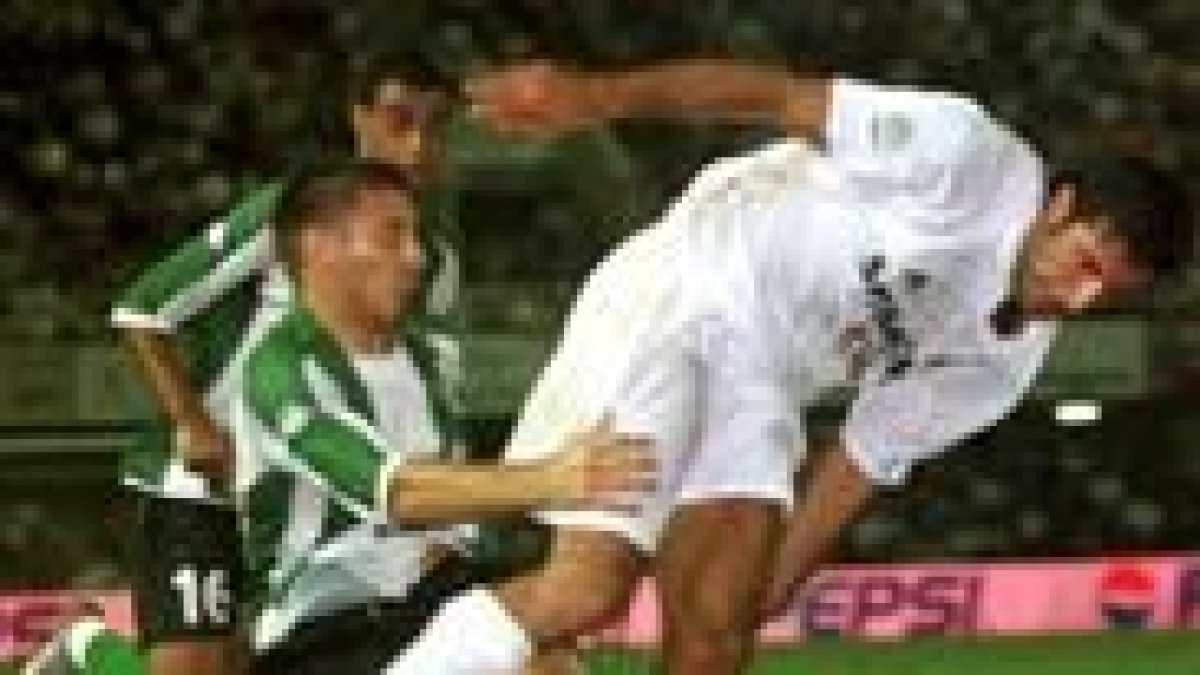 Figo y Varela, en un momento del partido entre el Madrid y el Betis