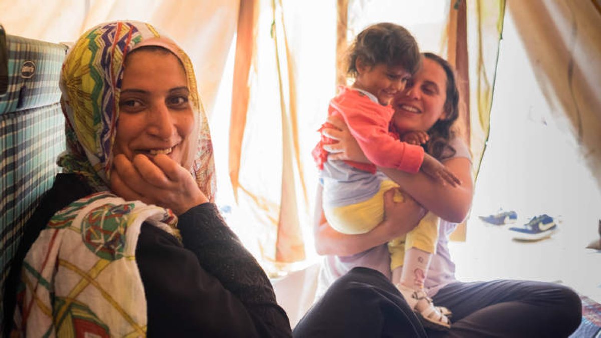 María Peñalosa, con un niño en brazos, en un campo en Grecia, desde donde trabaja para concienciar de la situación actual de las personas refugiadas. DL
