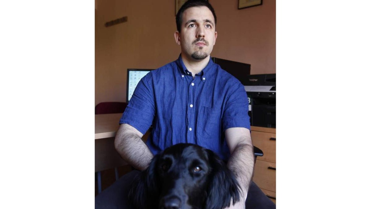 Luis Muñiz con su perro guía en el despacho del gabinete Logro, que dirige en León.