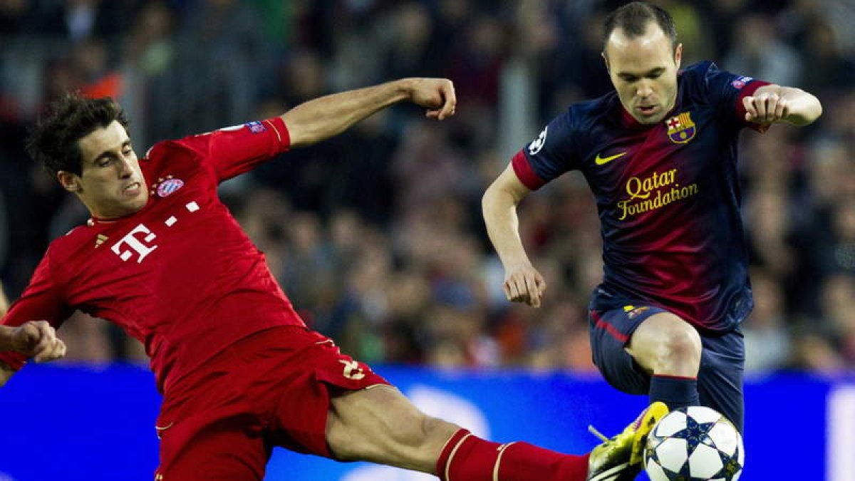 El centrocampista del Barcelona Andrés Iniesta avanza con el balón ante el jugador del Bayern Munich, Javi Martínez, durante el partido.