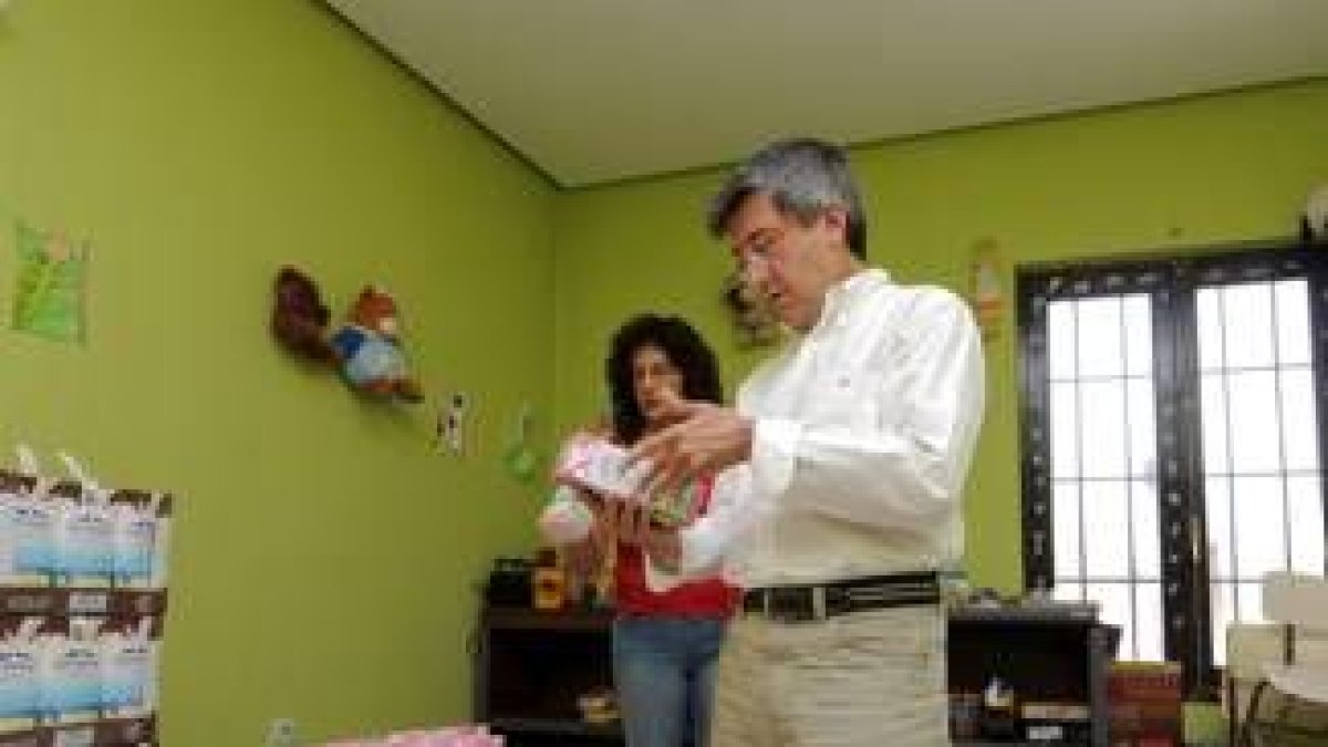 Fernández observa los alimentos del reparto con Gutiérrez detrás