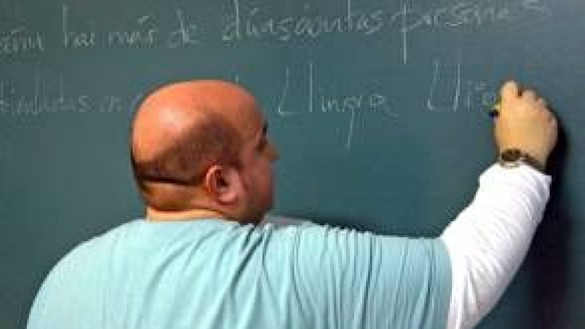 Un profesor de leonés escribe en la pizarra durante una clase, en imagen de archivo