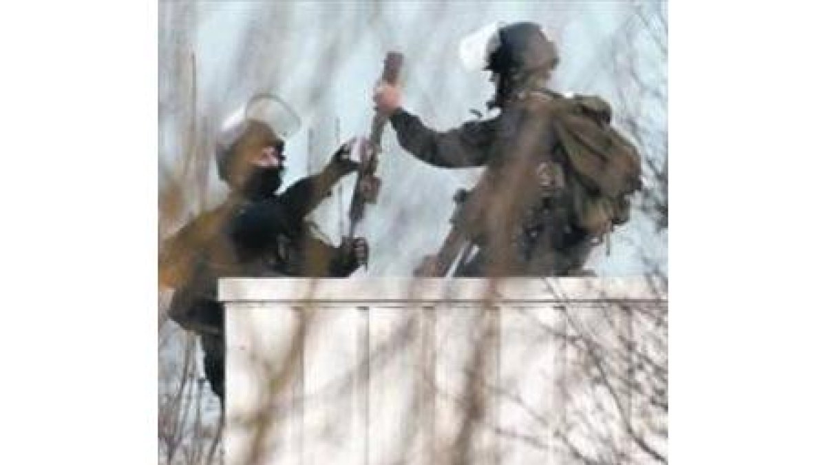 Varios policías intervienen en Dammartin-en-Göele. A la derecha, el Arco de Triunfo.