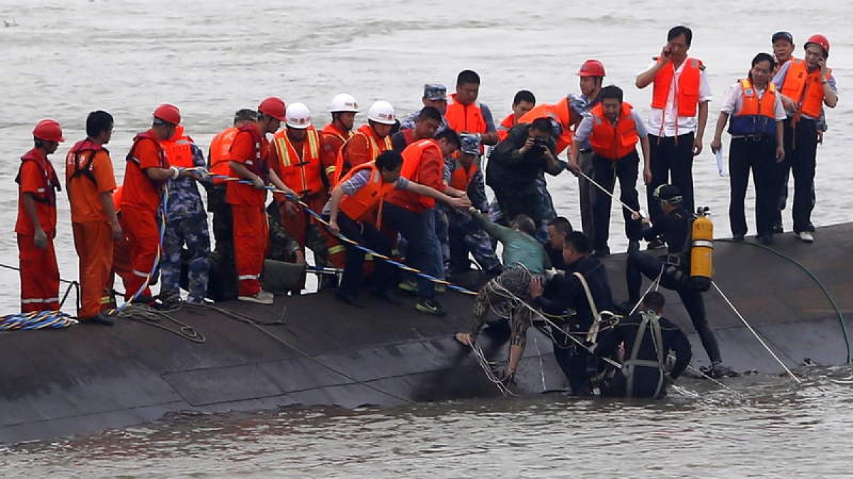 Momento en el que los equipos de rescate recuperan a uno de los pasajeros del barco.