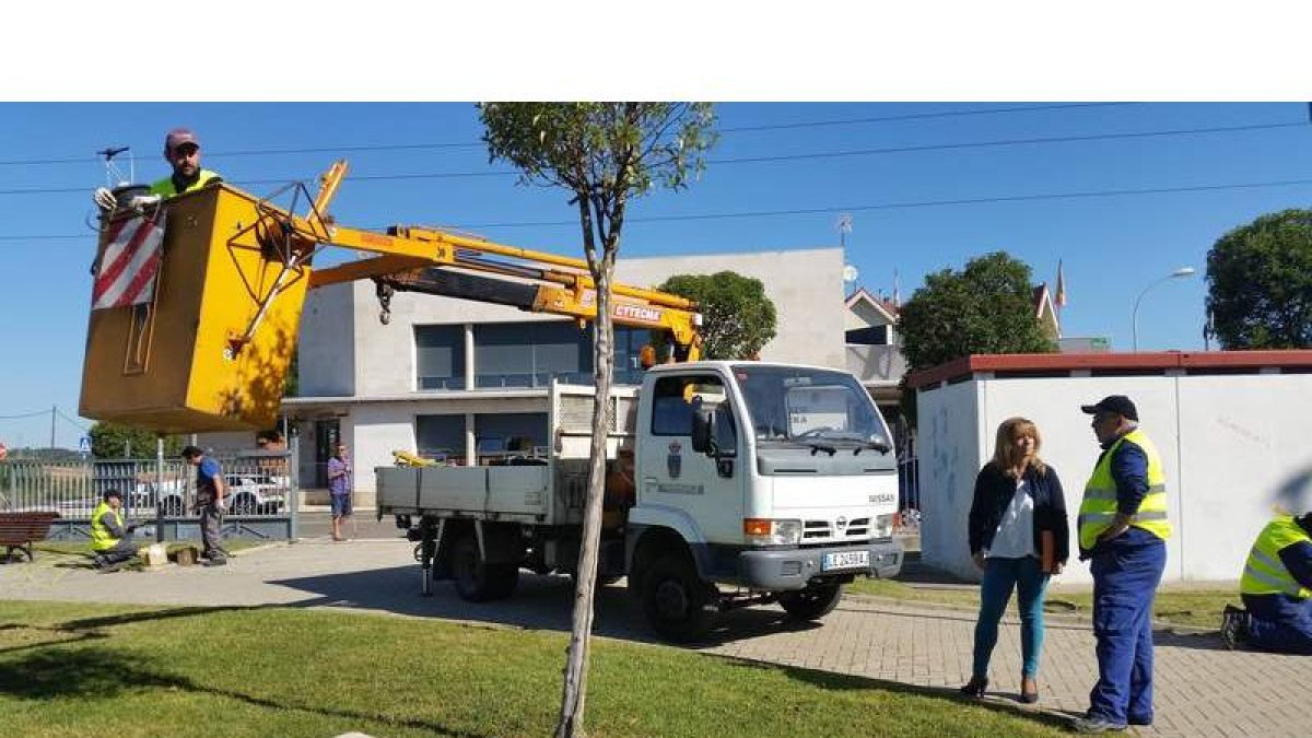 Un alumno se dispone a cambiar cables junto al centro cívico de Nava, en sus prácticas de electricidad.