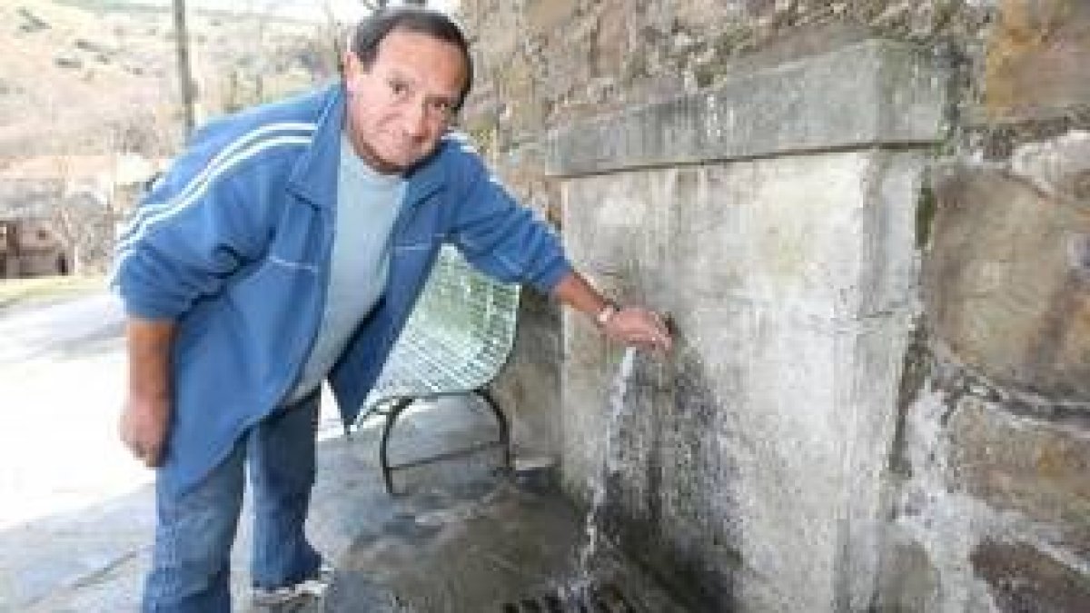 Un vecino de Lombillo comprueba el chorro de una de las fuentes de la localidad