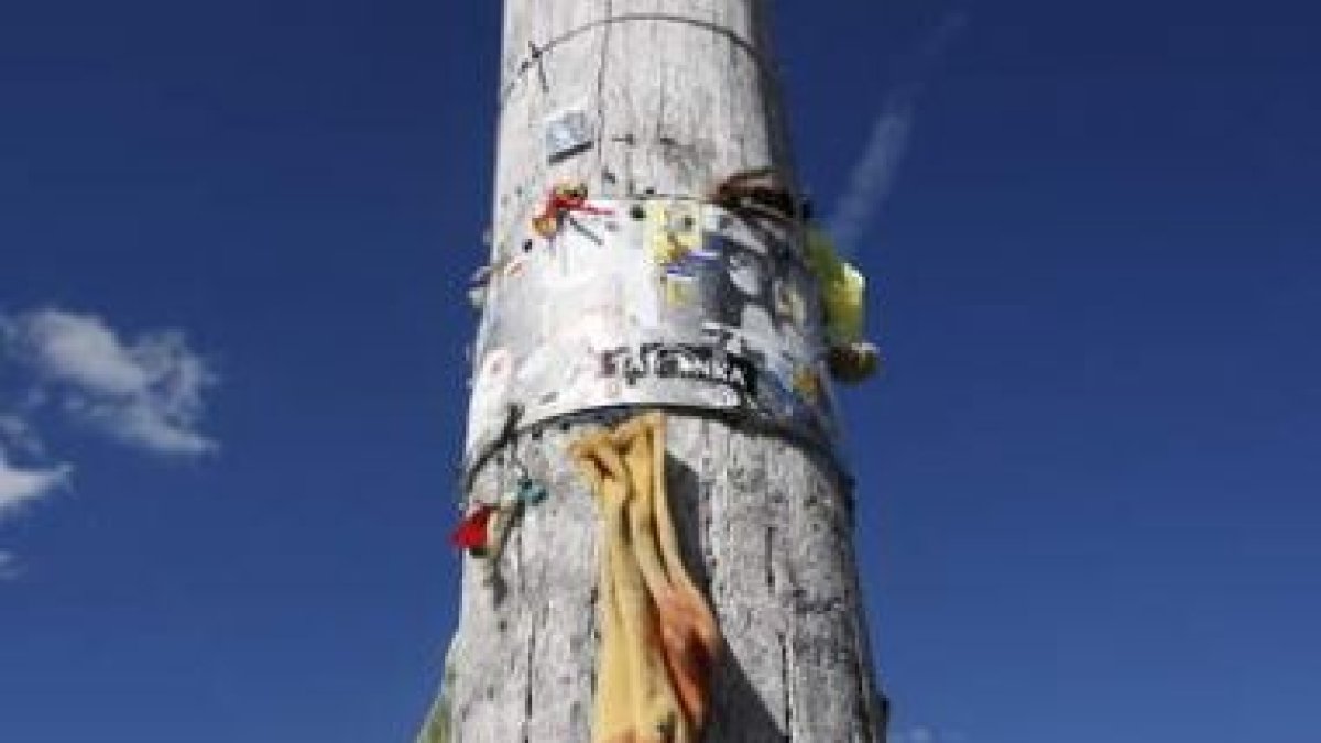 Uno de los numerosos postes del Camino adornado con enseres de los peregrinos.