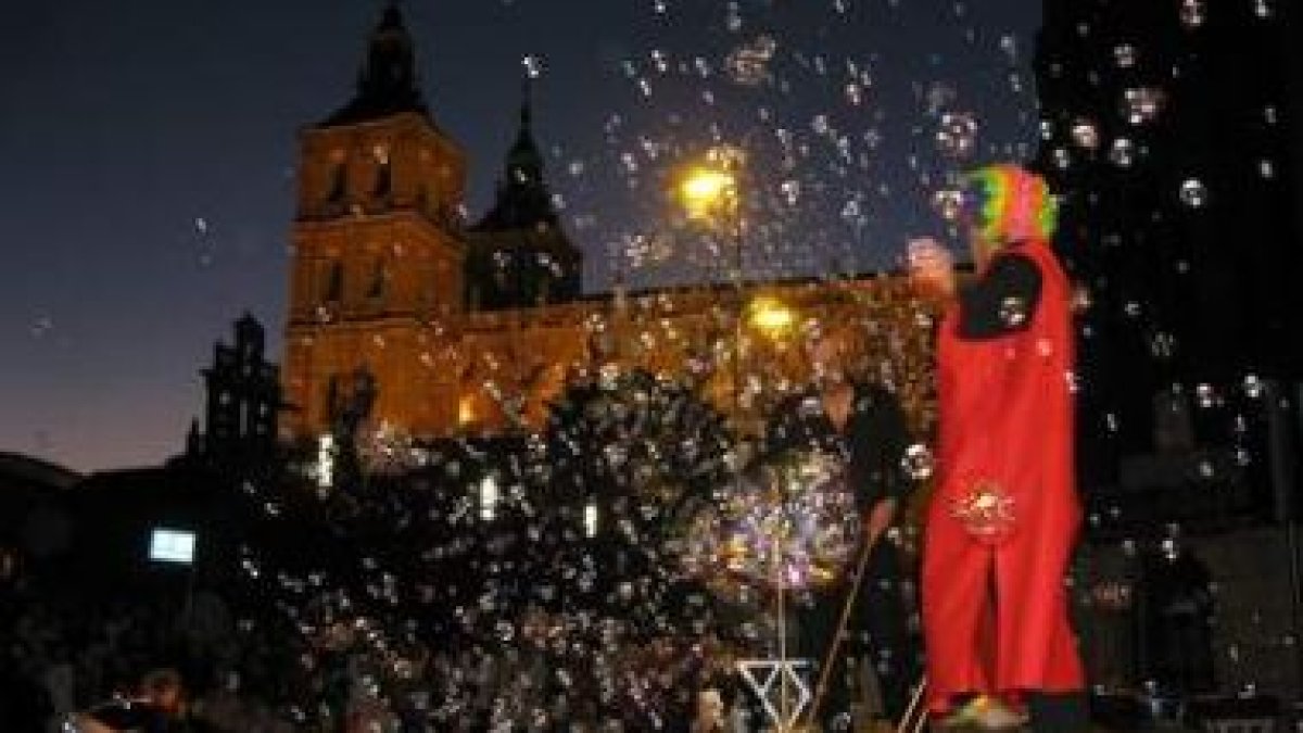 Dos actores, casi ocultos por las pompas, con la catedral de Astorga al fondo.