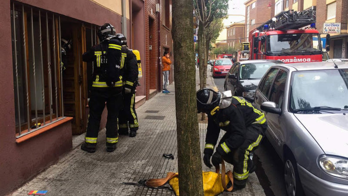 Los bomberos, durante su intervención en el piso incendiado en la calle San Juan de Sahagún. CANAL