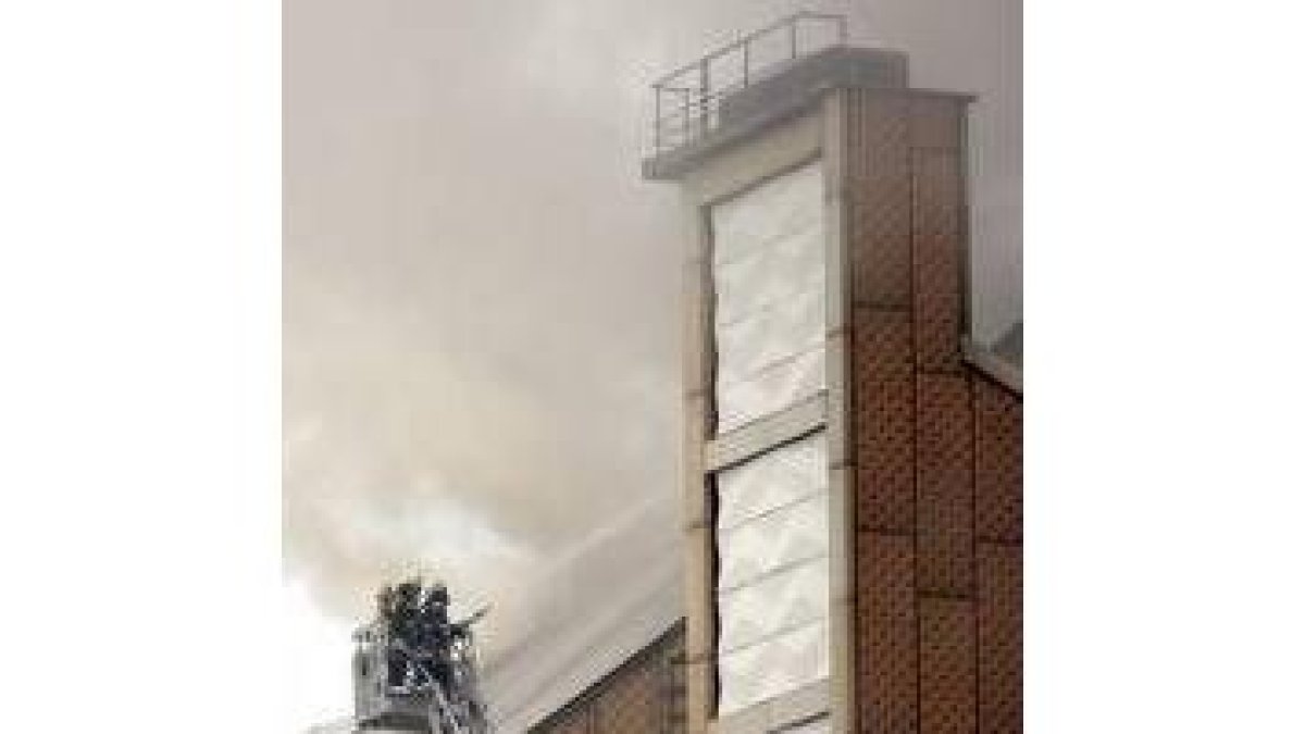 Dos bomberos intentando sofocar el incendio en la Filarmónica