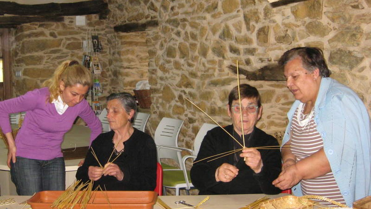 Eumenia Rodríguez y Dolores de Luis, de Torneros, enseñan a tejer el centeno en Villar del Monte.