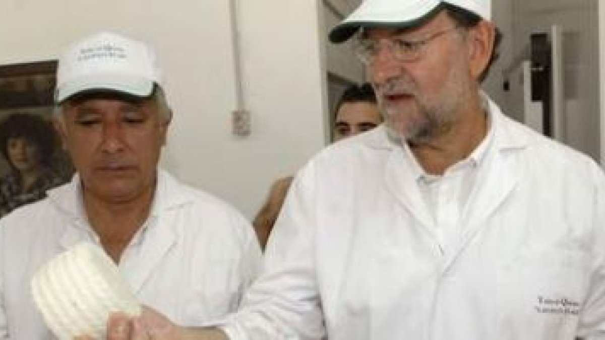 Rajoy muestra un queso al presidente del PP andaluz, Javier Arenas, en su estancia en la granja-escu