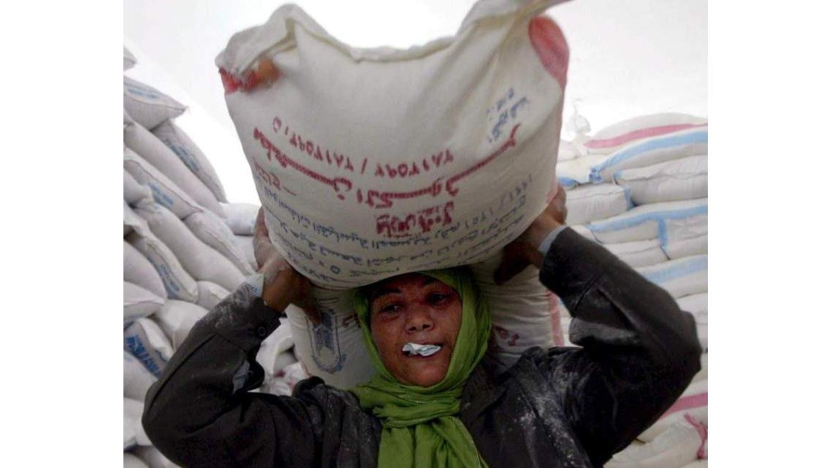 Una mujer palestina recibe un saco de comida del programa de alimentos. MOHAMMED SABER