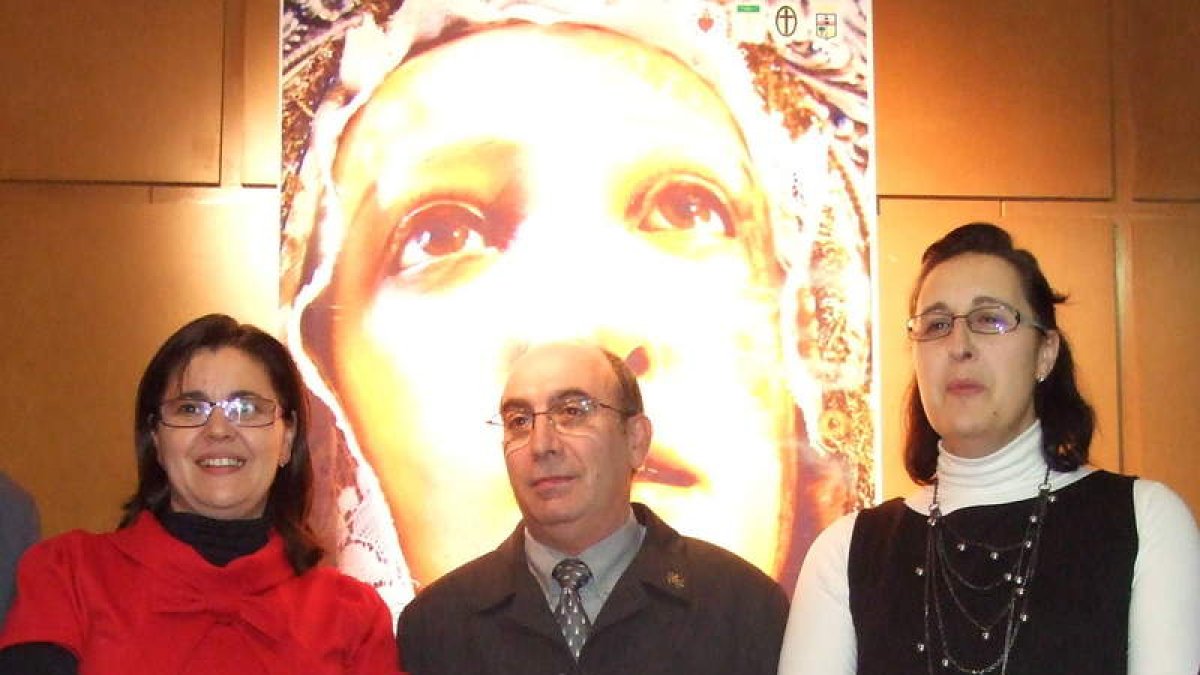 Luis Mantecón entre Piedad del Río y Carmen de la Torre delante del cartel.
