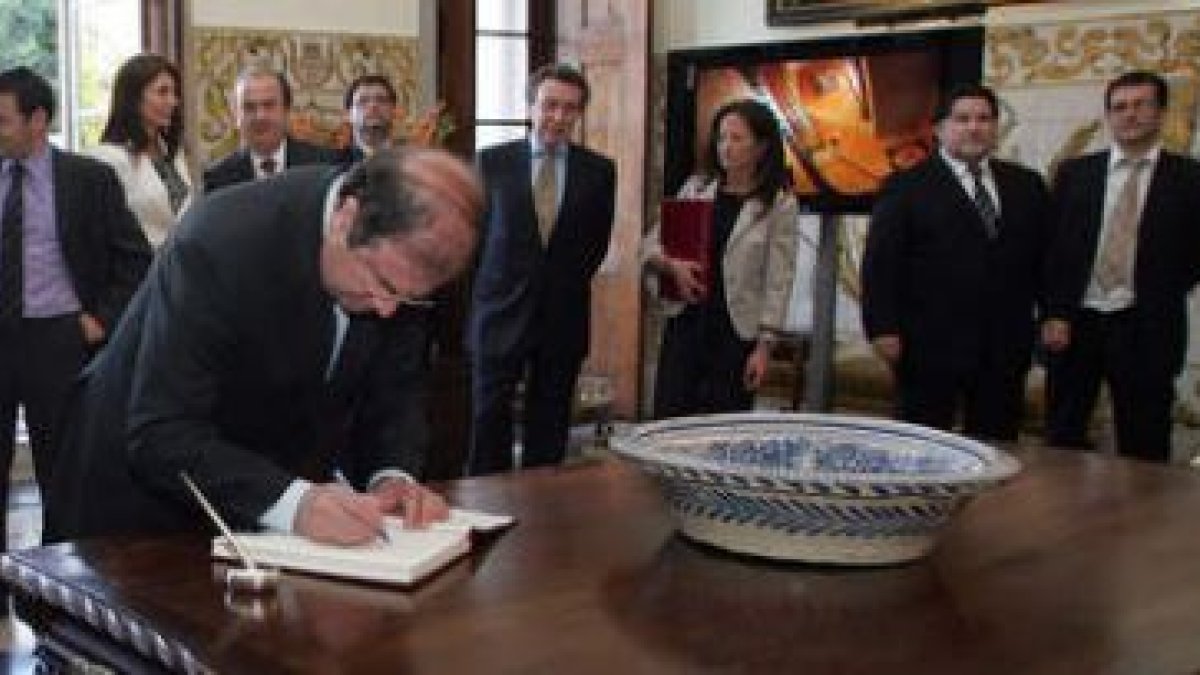 Herrera firma en el libro de honor de la embajada de España en la recepción que le ofreció el embaja