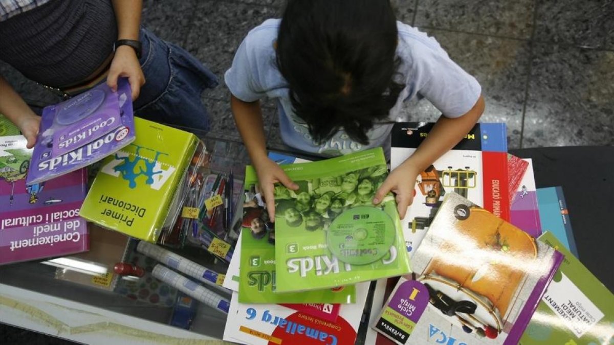 Dos niñas miran los libros de texto de su curso