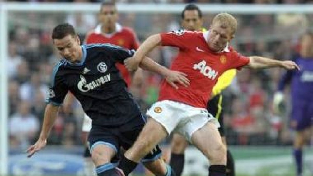 El jugador del Manchester, Paul Scholes, pelea por el balón con Alexander Baumjohan.