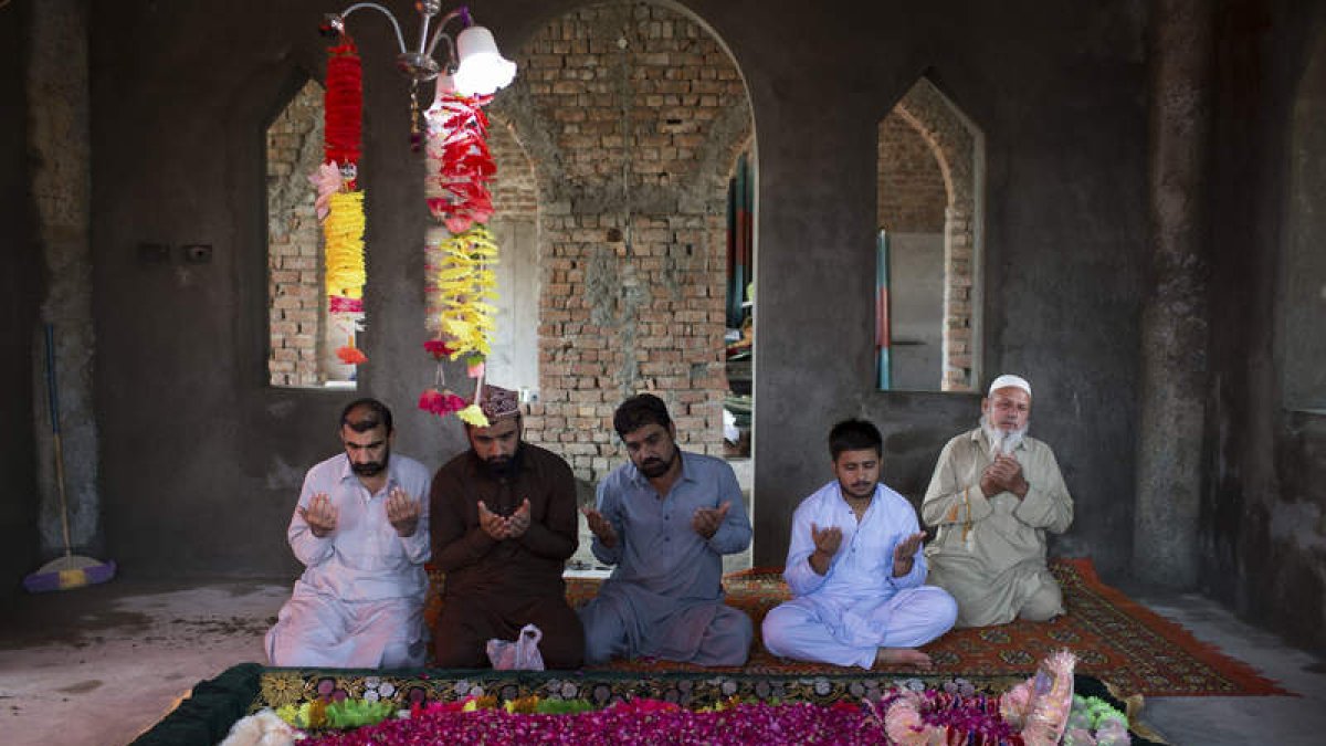 Fieles musulmanes rezan junto a la tumba de Mumtaz Qadri. JAIME LEÓN