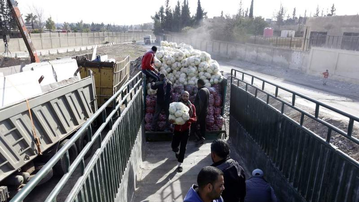 Varios trabajadores descargan comida de un camión en Damasco. YOUSSEF BADAWI