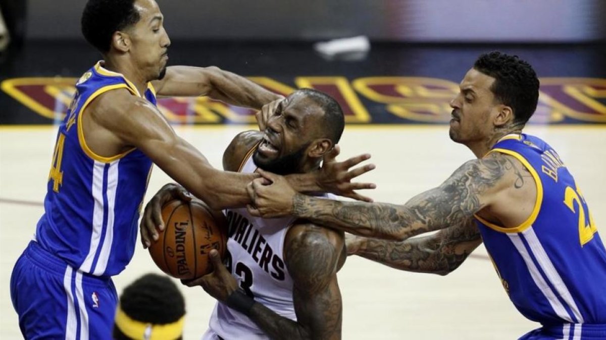 Lebron James entra a canasta ante el duro marcaje de Shaun Livingston y Matt Barnes.