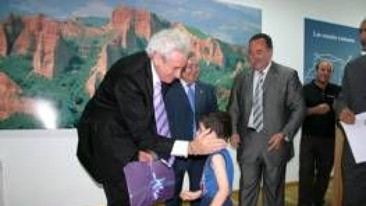 Luis del Olmo recibe un envoltorio con dibujos de los escolares de Puente, en el interior del centro