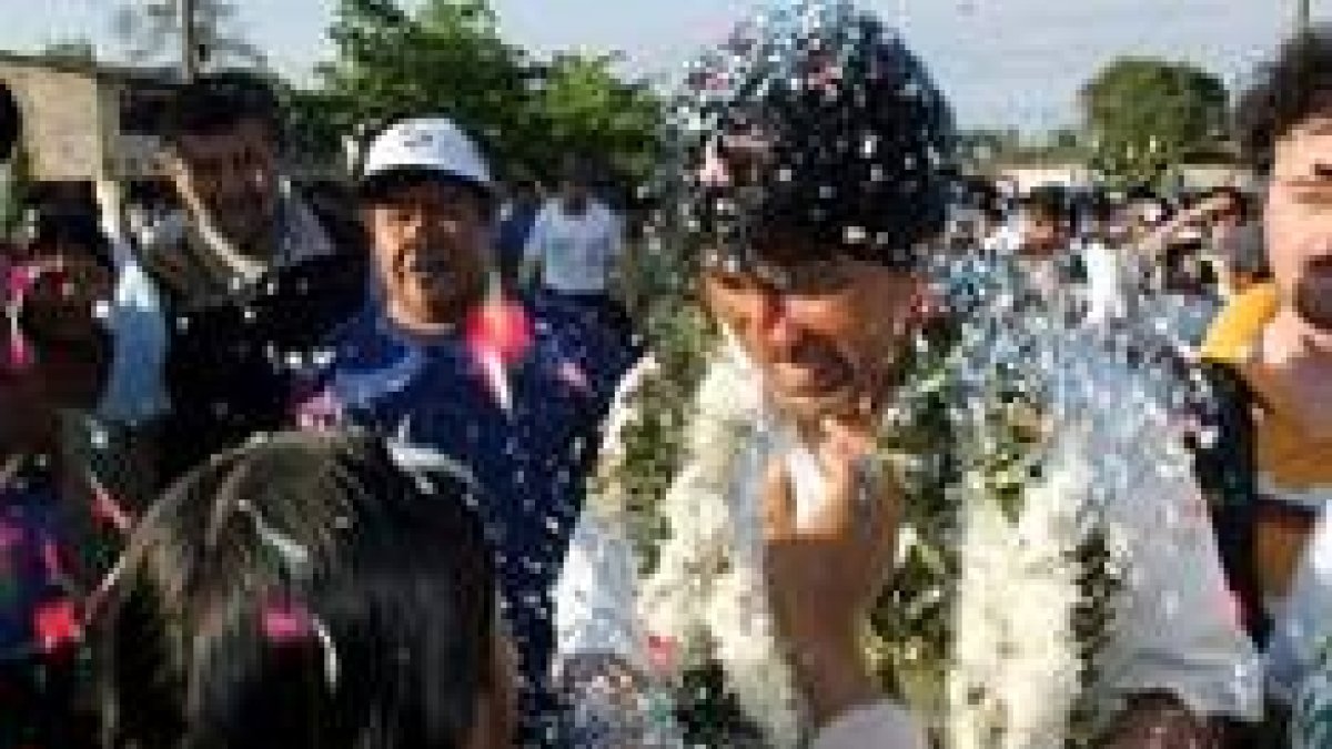 Evo Morales habla con una mujer mientras se dirige a una mesa electoral en Cochabamba