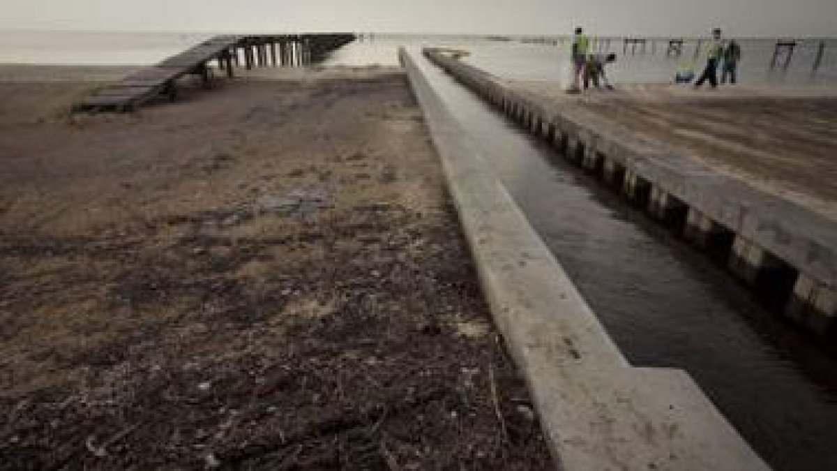 Trabajadores limpian la playa de petróleo y alquitrán, en Waveland, Mississippi.