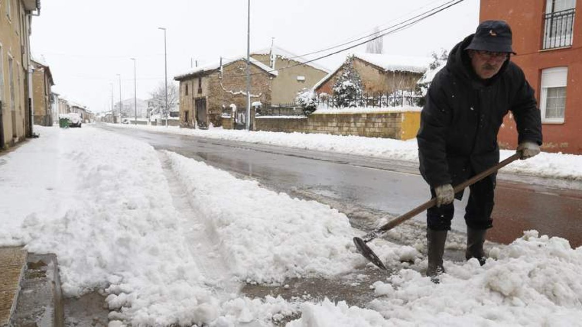 Un vecino de Boñar espala nieve a la puerta de su vivienda, una escena que se repitió en la mayoría de las zonas de montaña de la provincia