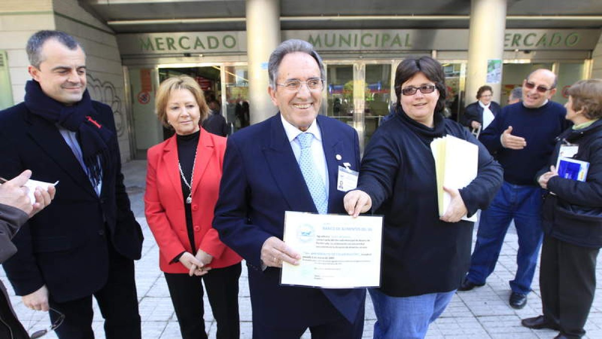 El presidente del Banco de Alimentos, rodeado de autoridades, con los diplomas para los comercios.