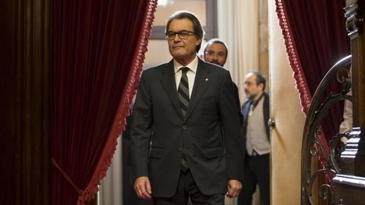 Artur Mas entra en el hemiciclo del Parlament, con Antonio Baños (CUP) al fondo.