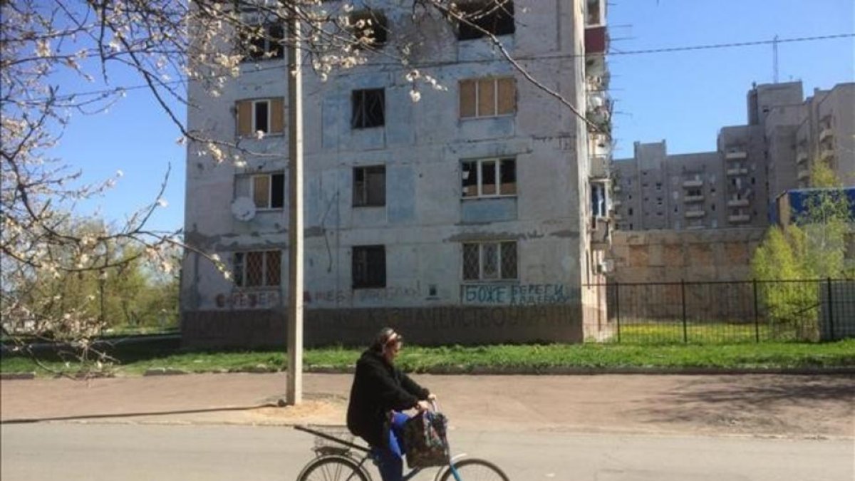 Una mujer pasa frente a un edificio afectado por los bombardeos en Avdiivka.