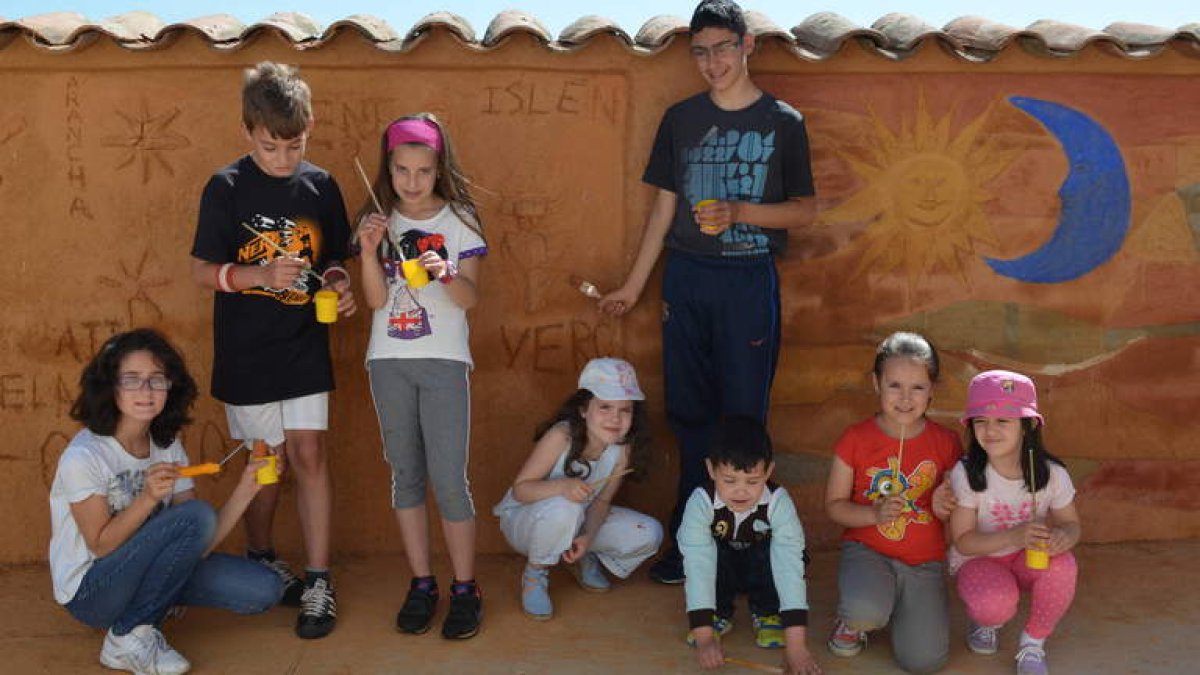 Los ocho niños y niñas que ha participado en esta actividad con la que han decorado a su gusto un muro del colegio.