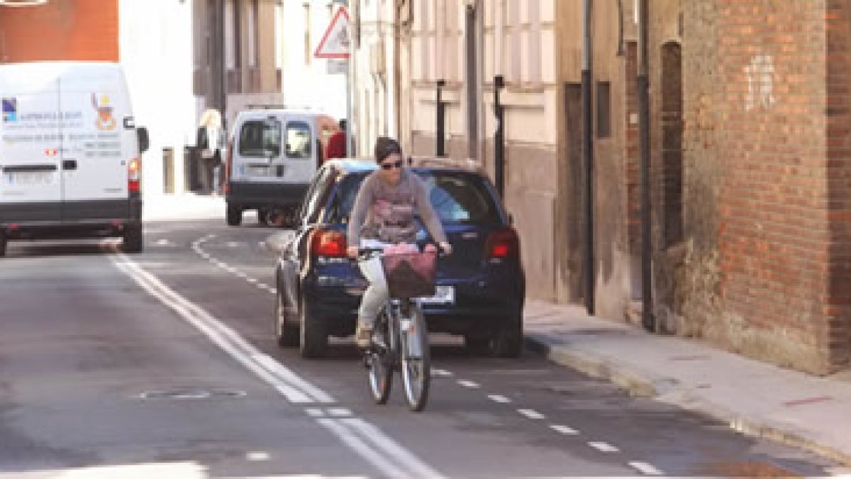 Una usuaria esquiva un coche que ocupa el carril bici en una calle próxima al Espolón.