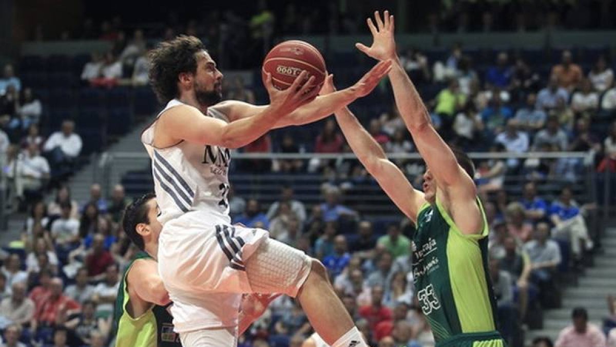 El ala pivot del Unicaja Nik Caner-Medley defiende la entrada del base del Real Madrid Sergio Llull, este domingo.