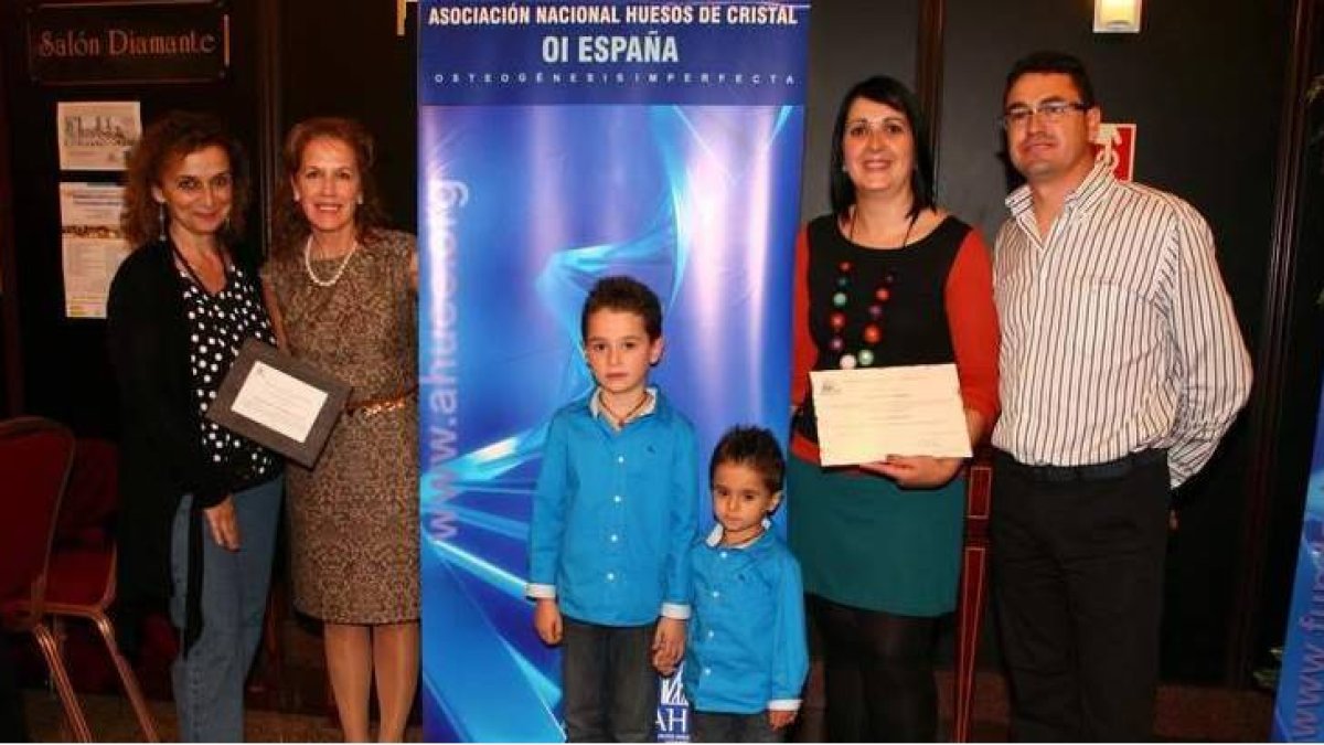 El pequelo Slavi, junto a su hermano, sus padres, la concejala y la presidenta nacional de Ahuce, durante la recogida del galardón.