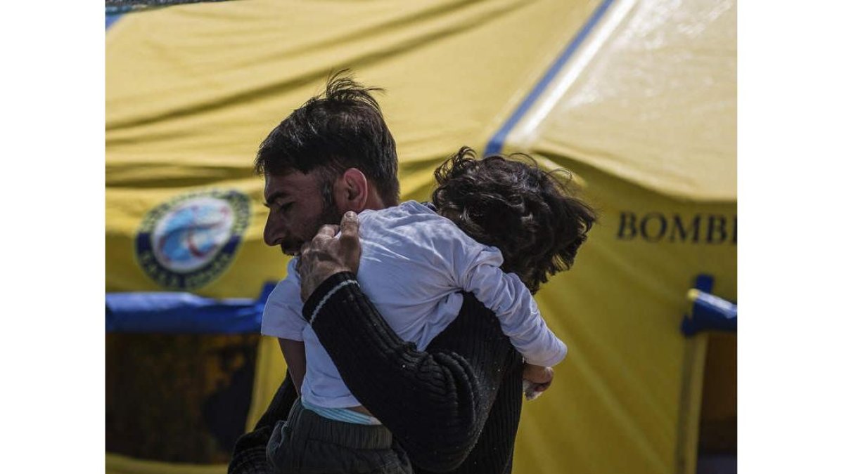 El padre de Osman con el niño en Idomeni. BOMBEROS EN ACCIÓN