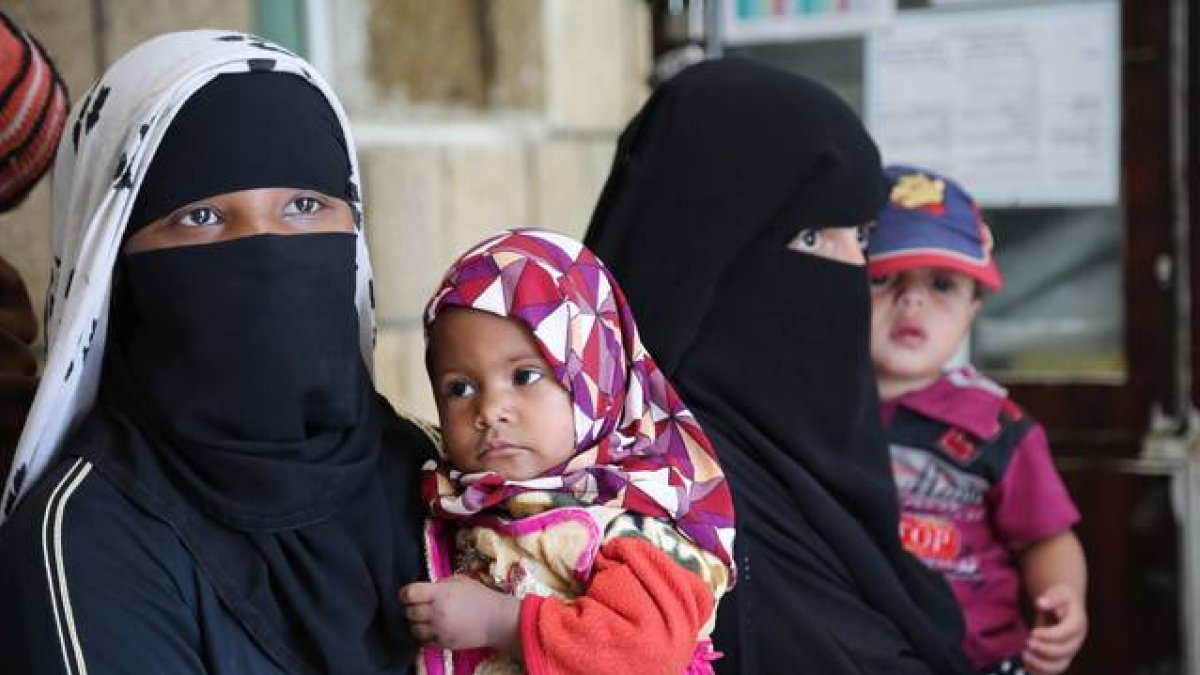 Una mujer yemení sostiene en brazos a su hija, en Saná.