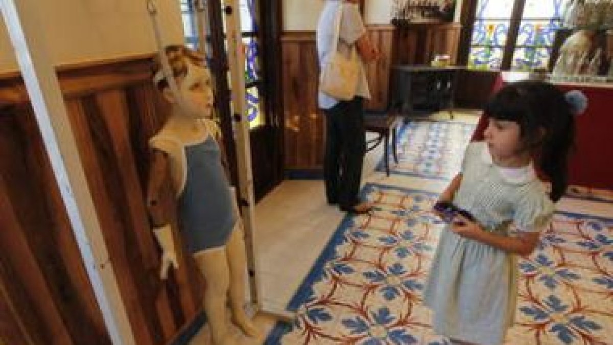 Dos épocas enfrentadas: una pequeña mira asombrada el artilugio para el crecimiento infantil.