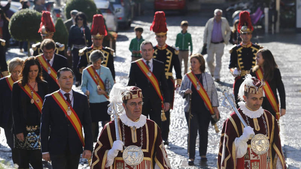 La corporación municipal sigue a los maceros por el centro de León. JESÚSLas autoridades, durante la celebración de la misa. JESÚS
