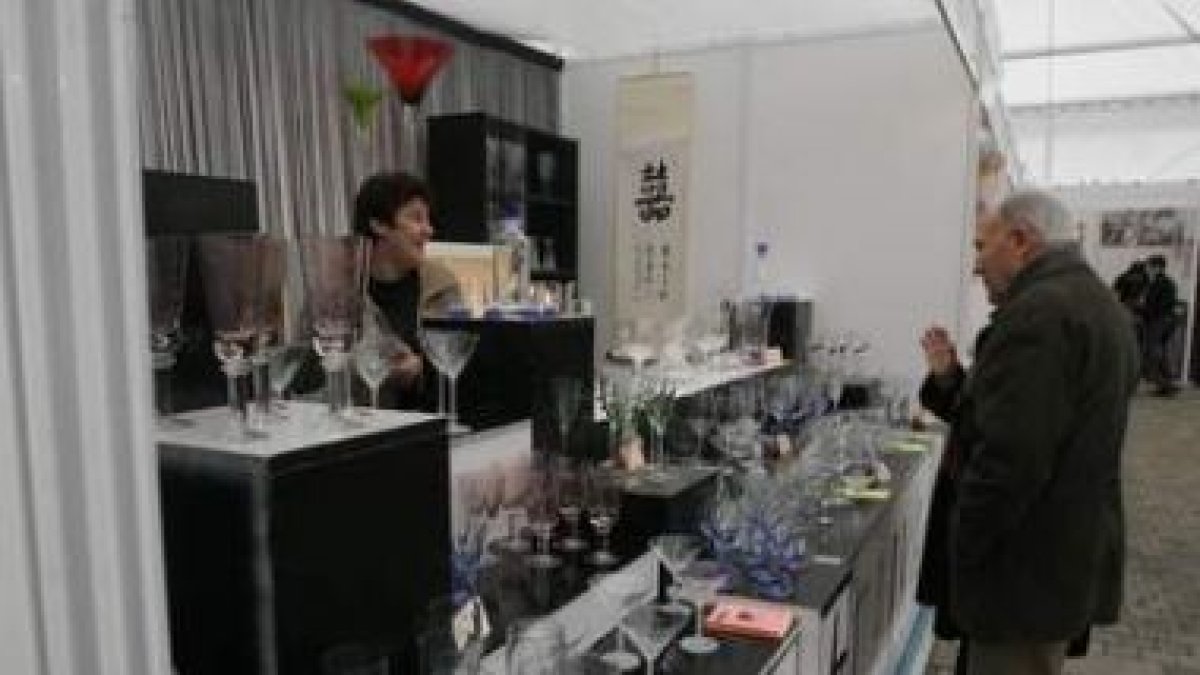 Pacios, Riesco y Téllez, observan los zapatos artesanales de un expositor de la feria