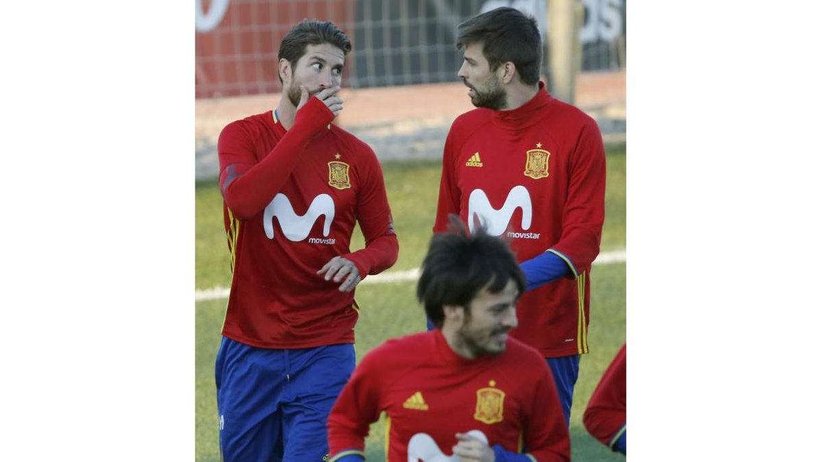 Ramos y Piqué, detrás de Silva, en uno de los entrenamientos de la selección española. KIKO HUESCA