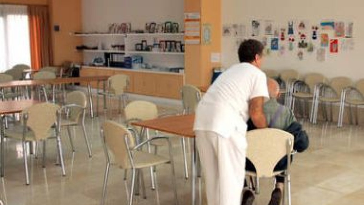 Un enfermero ayuda a una persona mayor en una residencia para la tercera edad