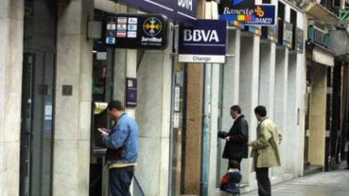 Varias personas sacan dinero de cajeros, en una imagen de archivo.