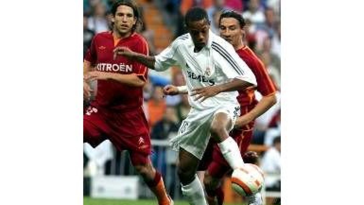 Robinho controla el balón ante la oposición de Dos jugadores del Celta