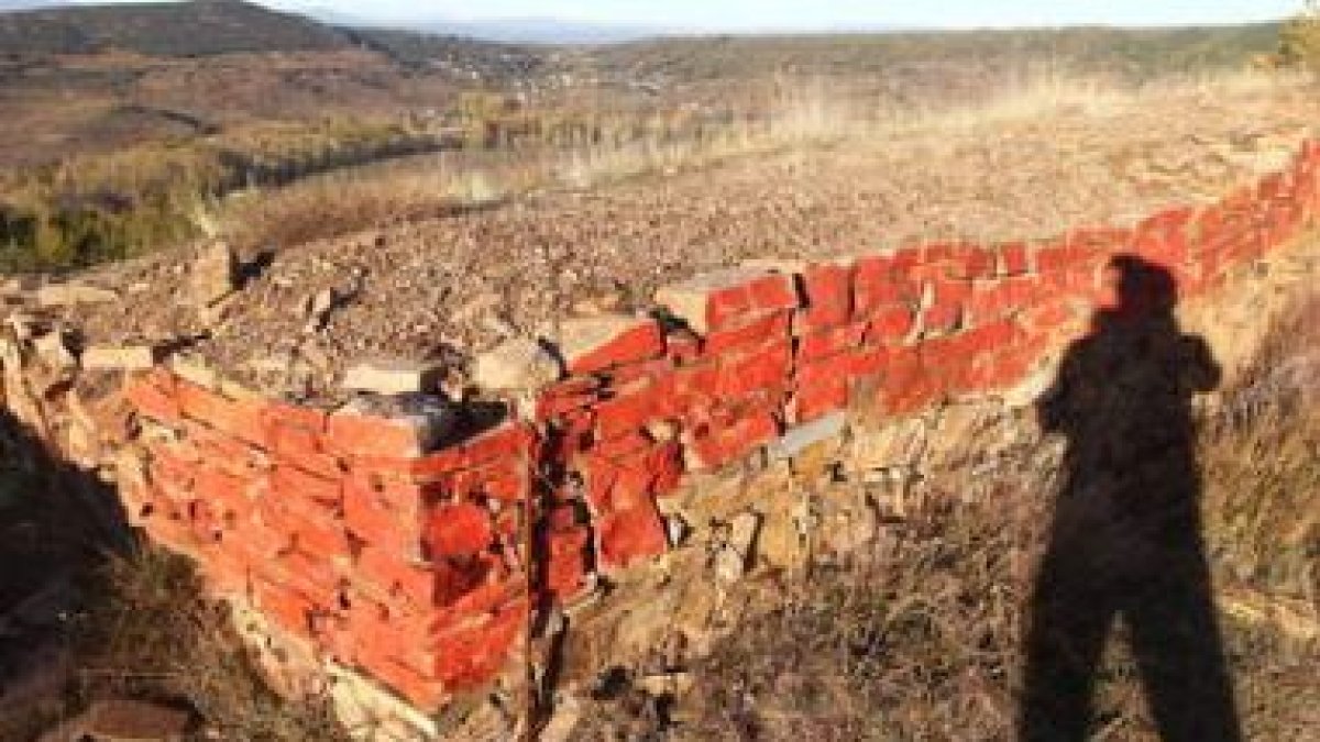 El autor de la pintada usó un aerosol rojo para marcar, piedra a piedra, un tramo de la muralla.