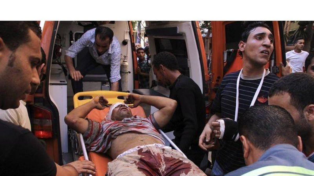 Manifestantes anti-Mursi lanzan piedras contra una sede de los Hermanos Musulmanes, en un barrio de El Cairo.