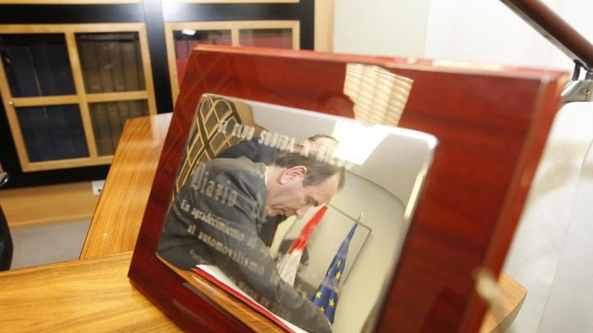 José Antonio Alonso se refleja en una placa conmemorativa durante una visita al Diario de León.