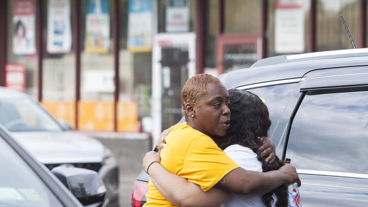 Dos mujeres se abrazan a la entrada del súper en el que ocurrió la matanza. BRANDON WATSON