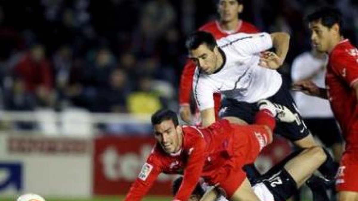 Navarro, a la izquierda, cae tras la entrada de los defensas vascos Descarga y Esnaola.